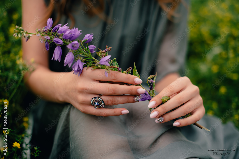 Fototapeta premium beautiful girl in green dress in flower field in spring outdoors