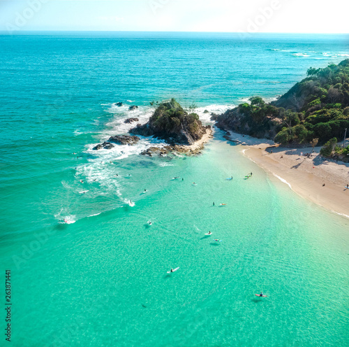 Stampa su tela Aerial shot at sunrise over the ocean and white sand beach with swimmers and sur