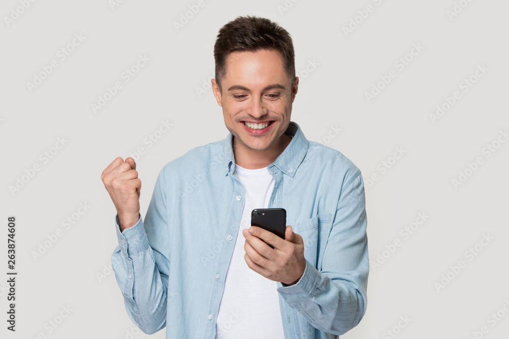 Happy Caucasian isolated excited get good message on mobile Happy Caucasian isolated excited get good message on mobile