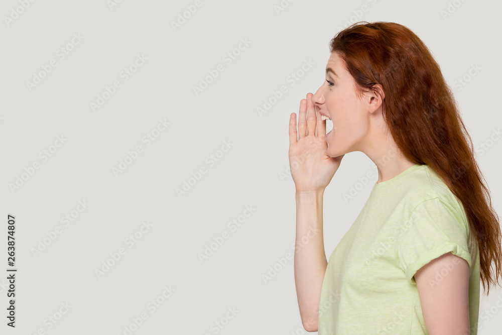 Excited redhead woman shout loudly about sale offer Excited redhead woman shout loudly about sale offer
