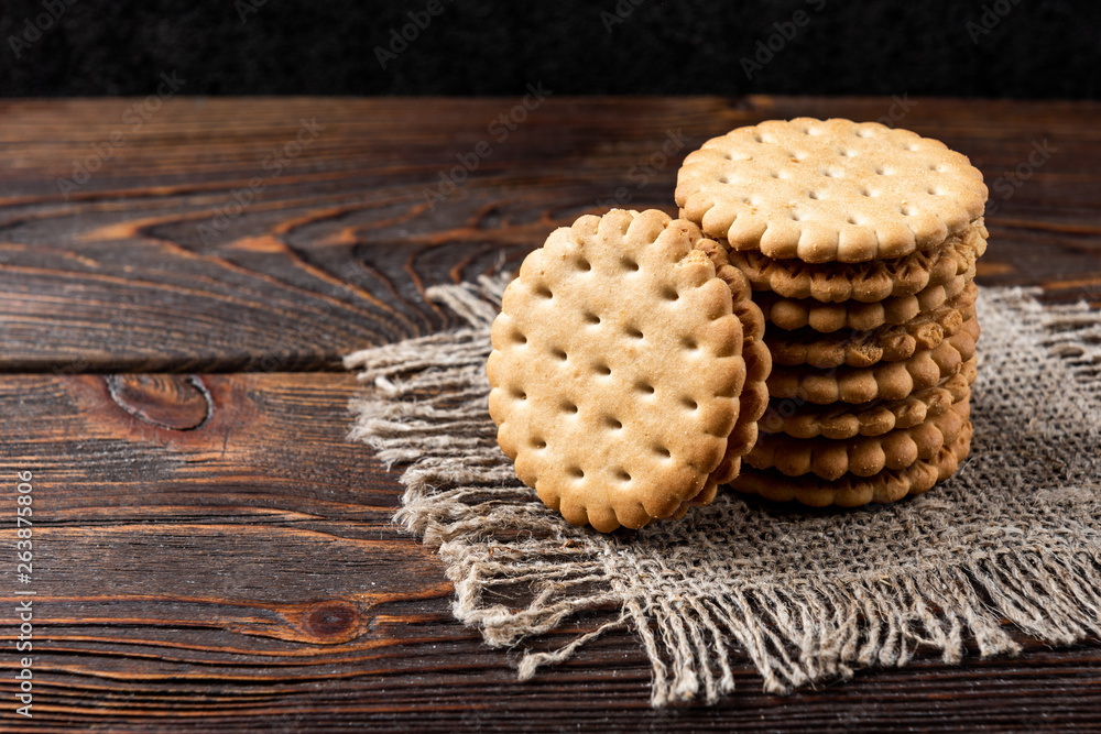 Cookies with milk filling on dark wooden background