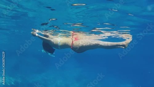 An underwater shot of a model floating on the water on this amazing Kalypso cretan beach photo