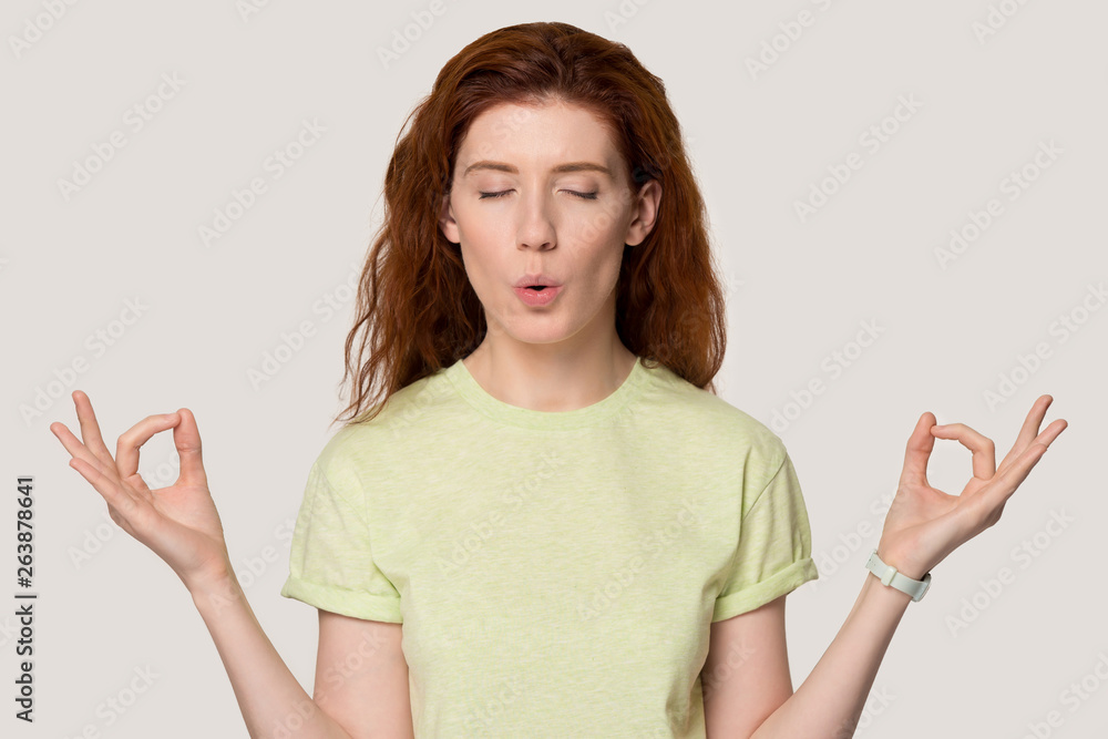 Young red-haired girl meditate practicing yoga in studio Young red-haired girl meditate practicing yoga in studio