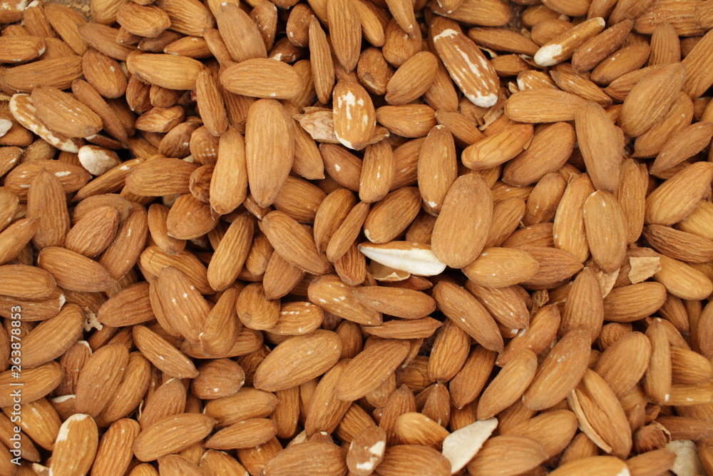 Overhead view of raw organic almonds as a background. Peeled almond nuts. Healthy food concept. Vegetarian. Overhead view of raw organic almonds as a background. Peeled almond nuts. Healthy food concept. Vegetarian.