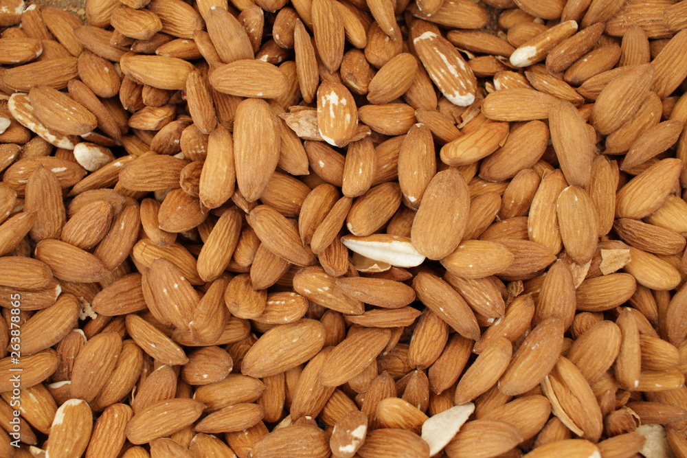 Overhead view of raw organic almonds as a background. Peeled almond nuts. Healthy food concept. Vegetarian. Overhead view of raw organic almonds as a background. Peeled almond nuts. Healthy food concept. Vegetarian.