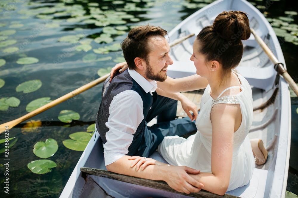 Scenic photo of a bride and groom in a rowing boat