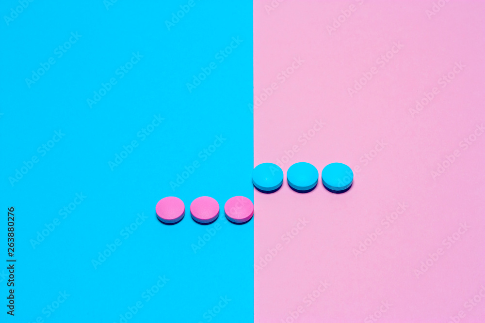 Pink and blue pills isolated on bicolor pink and blue colored background. Medication and prescription pills minimal flat lay with copy space.