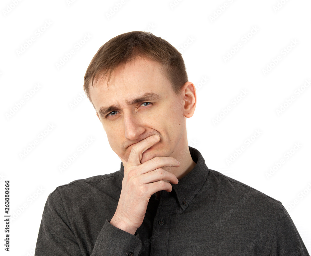 Young man rubs his chin in thought. Concept emotion bewilderment Young man rubs his chin in thought. Concept emotion bewilderment