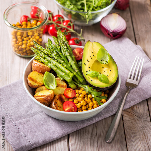 Healthy dinner with green asparagus, lentils and spicy chickpeas, avocado, arugula, vegan, vegetarian healthy food