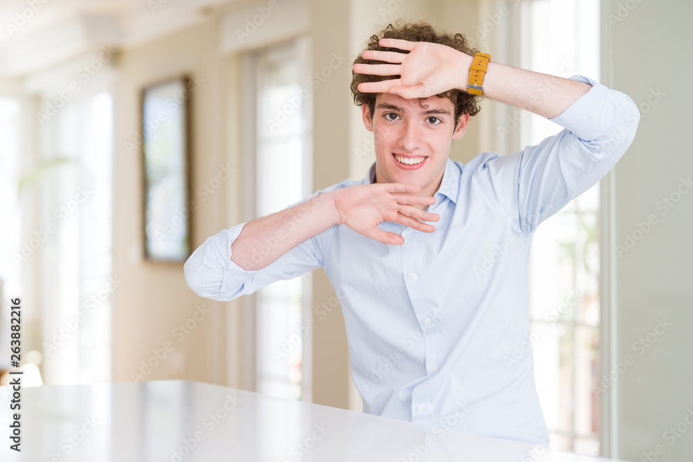 Young business man with curly read head Smiling cheerful playing peek a boo with hands showing face. Surprised and exited Young business man with curly read head Smiling cheerful playing peek a boo with hands showing face. Surprised and exited