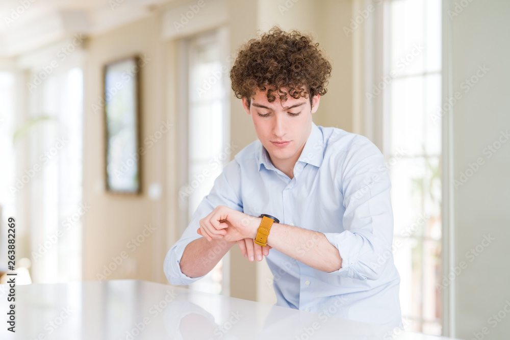 Young business man with curly read head Checking the time on wrist watch, relaxed and confident Young business man with curly read head Checking the time on wrist watch, relaxed and confident