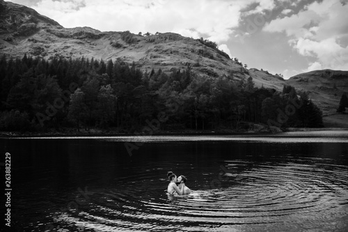 Couple being close to each other swimming in black and white