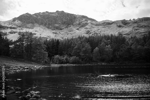 Black and white landscape of the lake district with couple swimming