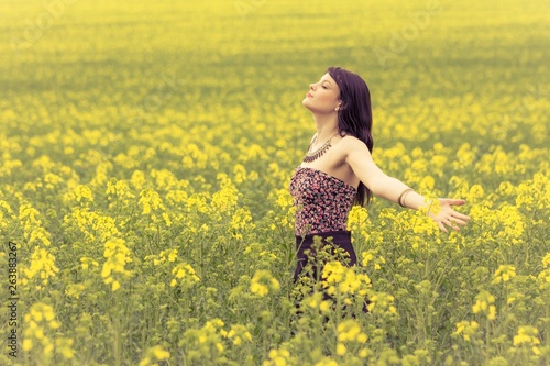 Happy beautiful woman in free summer love of youth wellbeing. Attractive young beauty girl enjoying the warm sunny sun in nature rapeseed field takes time feeling sustainability and contemplation © azur13