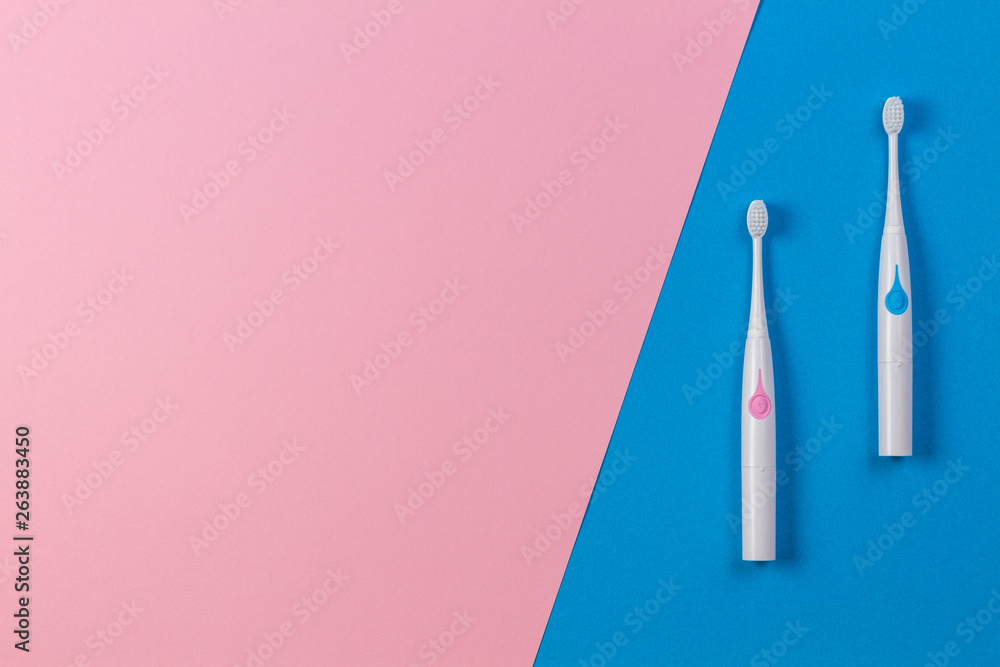 Two toothbrushes on blue and pink background. Top view Two toothbrushes on blue and pink background. Top view