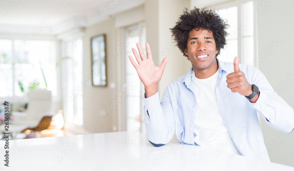 African American man at home showing and pointing up with fingers number six while smiling confident and happy. African American man at home showing and pointing up with fingers number six while smiling confident and happy.