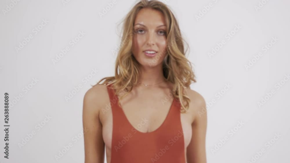 Young European blonde posing in an orange one piece bikini suit. Young European blonde posing in an orange one piece bikini suit.