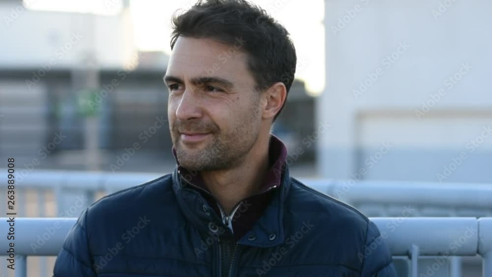 Handsome man smiling waiting on the street on a cold day. Handsome man smiling waiting on the street on a cold day.