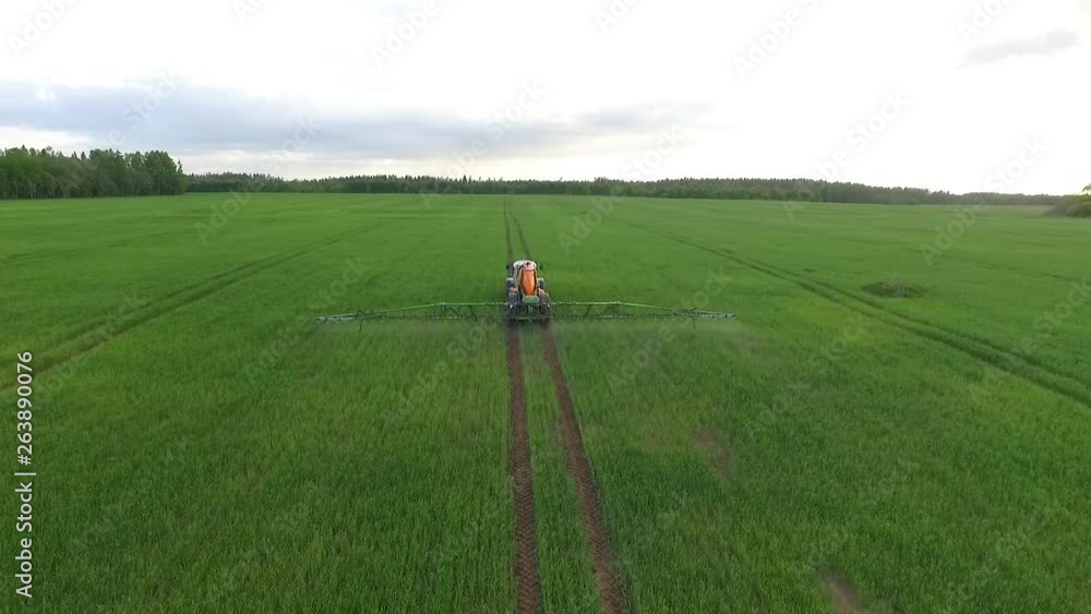 Pesticide and fertilizer spraying on the field aerial view with tractor Pesticide and fertilizer spraying on the field aerial view with tractor