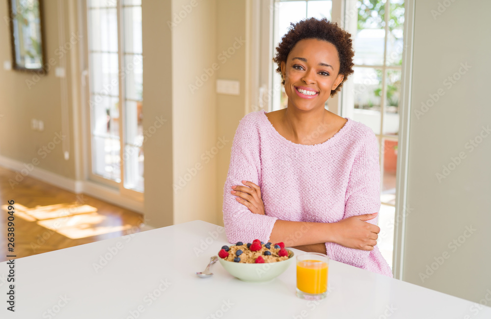 Young african american woman having healthy breakfast in the morning at home happy face smiling with crossed arms looking at the camera. Positive person. Young african american woman having healthy breakfast in the morning at home happy face smiling with crossed arms looking at the camera. Positive person.