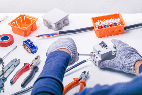 electrician with tools and electrical equipment photo