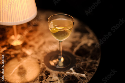 Close-up of alcohol cocktail with lemon rind on table