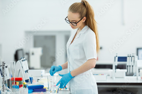 Pipette dropping a sample in a test tube. Laboratory assistant analyzing blood in lab. Aids  hiv test