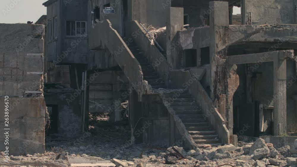 Damaged and partly destroyed look at concrete stairs linked to damaged buildings on Hashima Island, commonly called Gunkanjima, Nagasaki, Japan Damaged and partly destroyed look at concrete stairs linked to damaged buildings on Hashima Island, commonly called Gunkanjima, Nagasaki, Japan