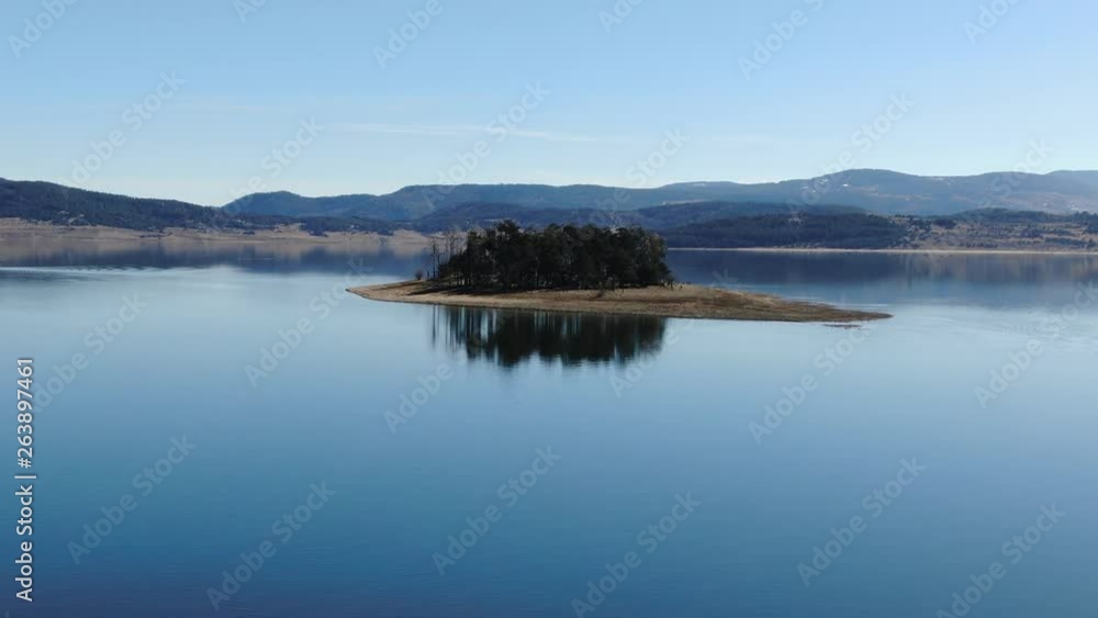 Aerial view of isolated small forest island in a lake with birds Aerial view of isolated small forest island in a lake with birds