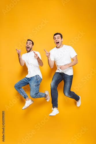 Full length of two cheerful excited men friends