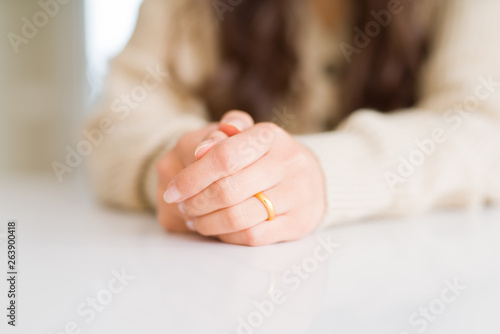 Close up of woman crossed hands wearing a golden alliance for marriage
