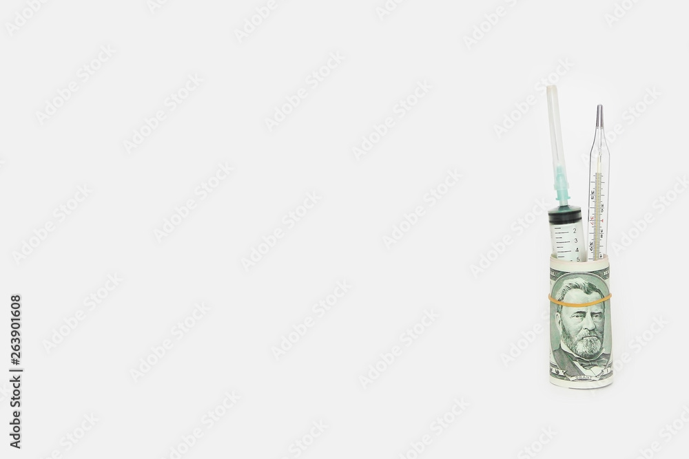 medical syringe and thermometer in a roll of dollars on a white background medical syringe and thermometer in a roll of dollars on a white background