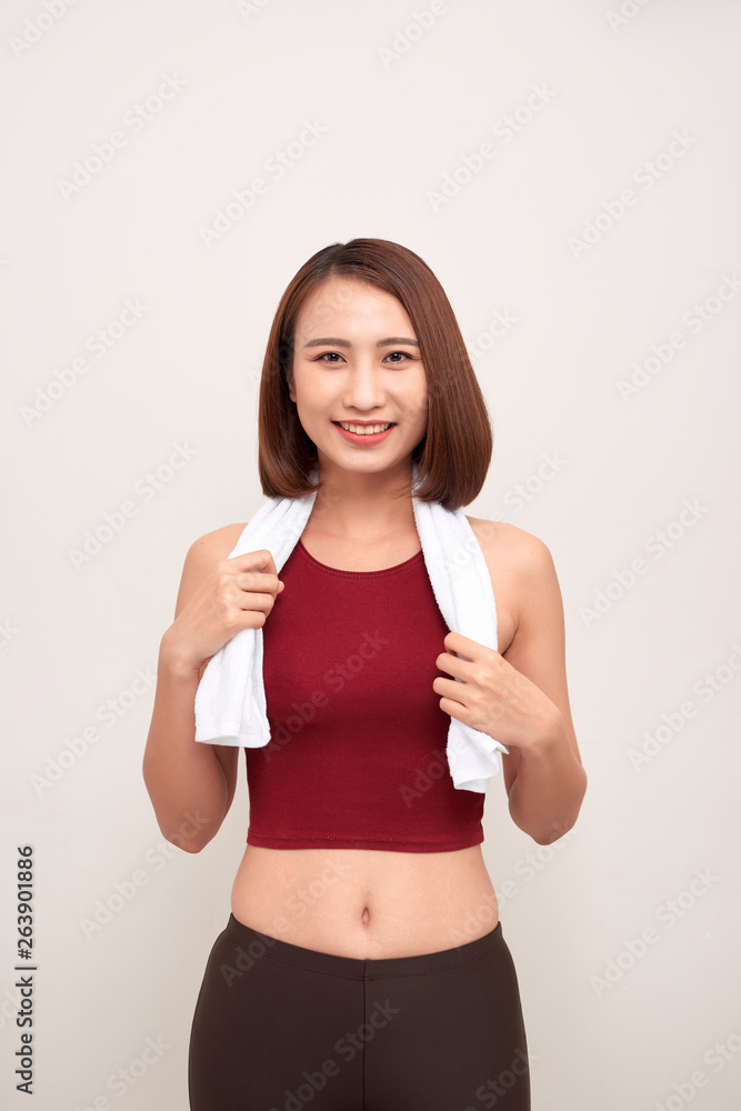 Sporty young woman with towel on light background Sporty young woman with towel on light background