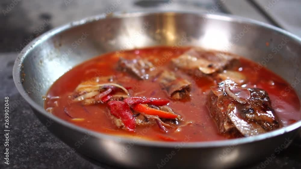 Close up detailed view on vegetable pork ragout simmering in hot tomato sauce on frying pan Close up detailed view on vegetable pork ragout simmering in hot tomato sauce on frying pan