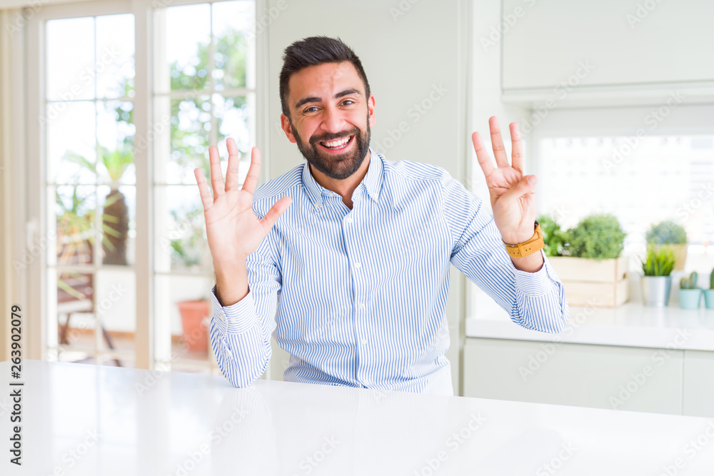 Handsome hispanic business man showing and pointing up with fingers number eight while smiling confident and happy.