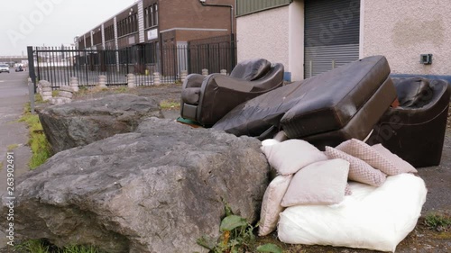 Pan left shot of worn out furniture on the streets in front of a wear-house photo