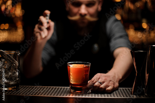 Male bartender holding a small steel sprayer