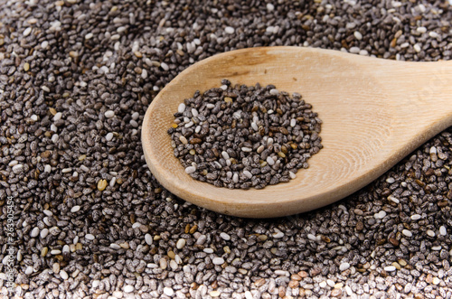 Chia seeds in wood bowl, isolated on white background.