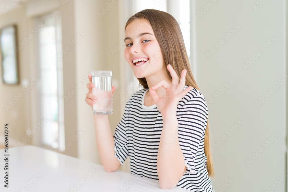 Beautiful young girl kid drinking a fresh glass of water doing ok sign with fingers, excellent symbol Beautiful young girl kid drinking a fresh glass of water doing ok sign with fingers, excellent symbol