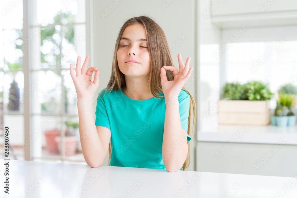 Beautiful young girl kid wearing green t-shirt relax and smiling with eyes closed doing meditation gesture with fingers. Yoga concept. Beautiful young girl kid wearing green t-shirt relax and smiling with eyes closed doing meditation gesture with fingers. Yoga concept.