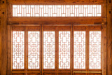 Closeup Chinese old wooden frame door with decorative pattern under the sunshine ,view from inside of building.