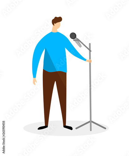 Young Man in Blue Shirt Standing with Microphone.