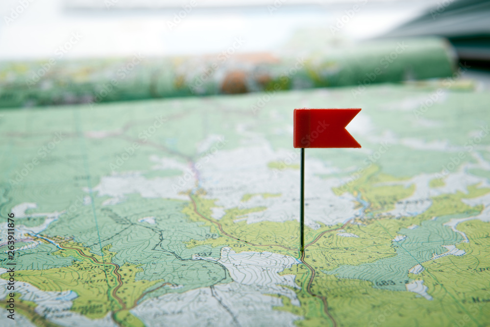 Obraz premium topographic map with colored flag pushpin close up