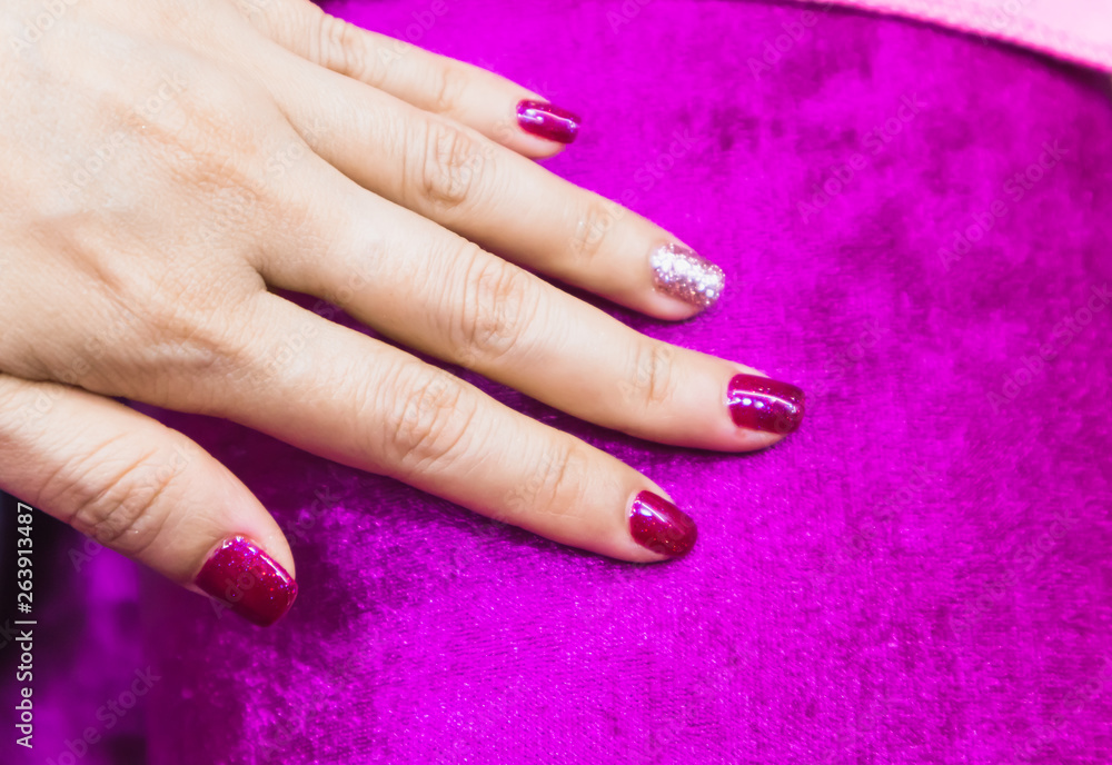 Bright festive drak pink manicure on female hands Bright festive drak pink manicure on female hands