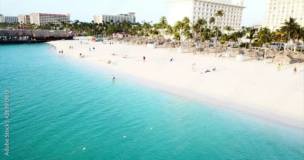 Aerial Pan Left to Right: People Enjoying the Beach of Oranjestad Aruba in Oranjestad, Aruba