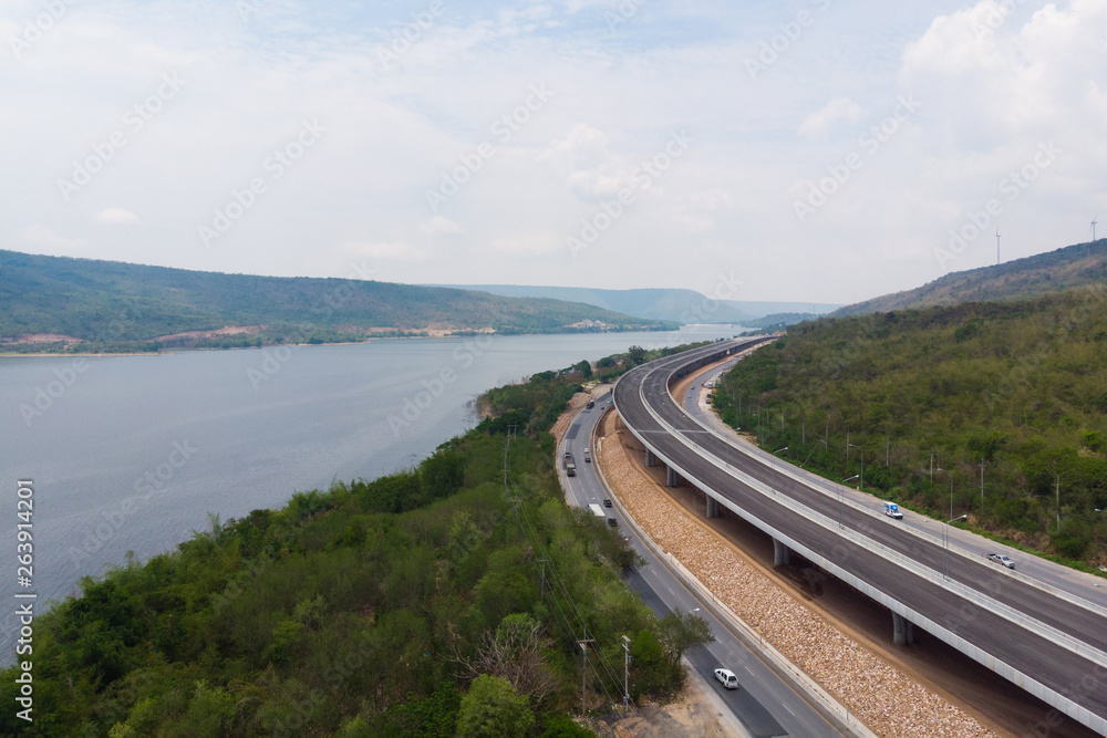 Drone shot aerial view landscape of under construction motorway tolls near big natural river Drone shot aerial view landscape of under construction motorway tolls near big natural river