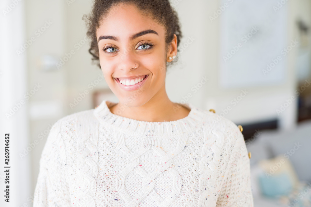 Beautiful young african american woman with afro hair wearing casual sweater with a happy and cool smile on face. Lucky person. Beautiful young african american woman with afro hair wearing casual sweater with a happy and cool smile on face. Lucky person.