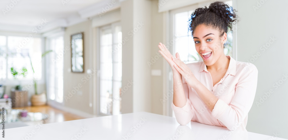 Wide angle of beautiful african american woman with afro hair clapping and applauding happy and joyful, smiling proud hands together Wide angle of beautiful african american woman with afro hair clapping and applauding happy and joyful, smiling proud hands together
