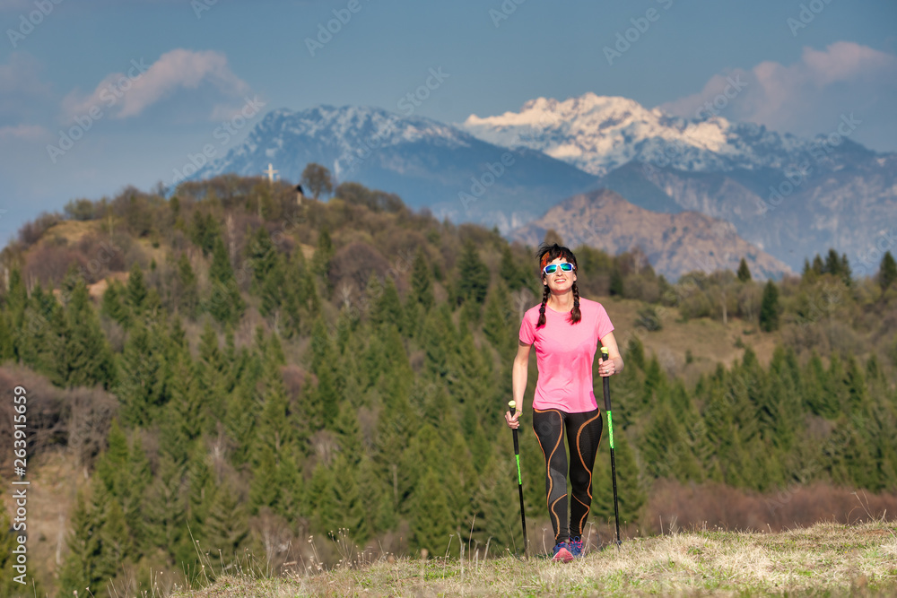 Naklejka premium Spring in the mountains between green and snow. A lonely girl during a trek