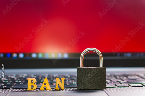 padlock and letters of ban on laptop keyboard. the concept of the prohibition.